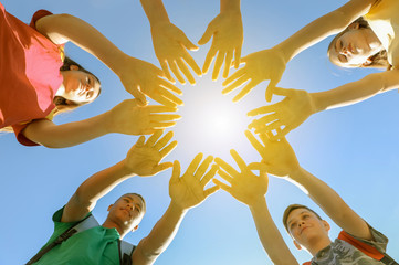 Group of volunteers putting hands together outdoors, bottom view