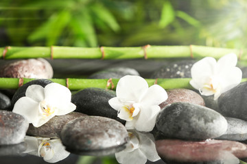 Spa stones with flowers and bamboo branches in water - obrazy, fototapety, plakaty