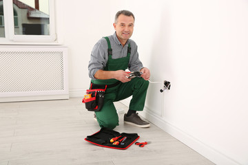 Professional electrician stripping wire ends with cutter indoors