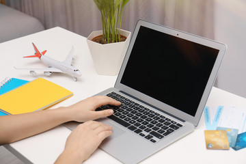 Professional manager working at laptop in travel agency, closeup