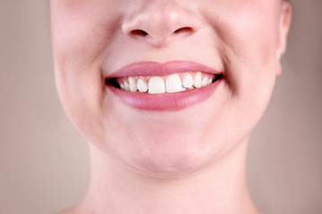 Young woman with healthy teeth smiling on color background, closeup
