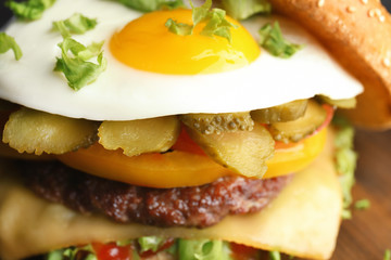 Closeup view of tasty burger with fried egg