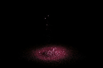 Heap of rose glitter with bokeh effect on black background