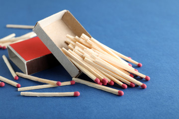 Open box and scattered matches on color background