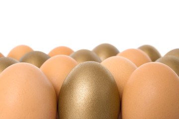 Golden eggs among others on white background