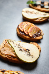 Tasty toast with pear, peanut butter and chia seeds on grey table