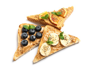 Different toasts with fruits, blueberries, peanut butter and chia seeds on white background