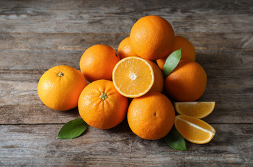 Fresh oranges with leaves on wooden background