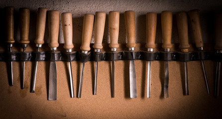 Wood Carving Tools hang on a wall inside a workshop