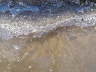 Texture of melting snow on the sidewalk closeup in Russia in early spring