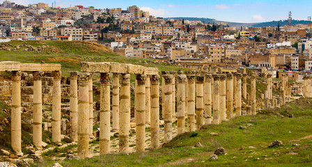 Roman columns with modern city in background at Jerash in Jordan