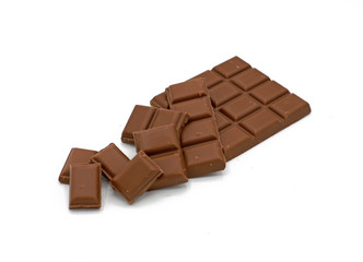 Milk chocolate bar and chocolate pieces isolated on white background