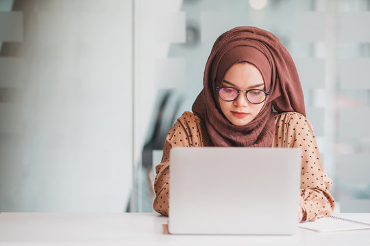 A young muslim woman using laptop