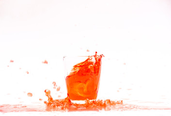 Red juice splash in glass isolated on white background