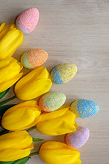 Fototapeta na wymiar colorful Easter eggs with spring flowers on wooden background, easter background