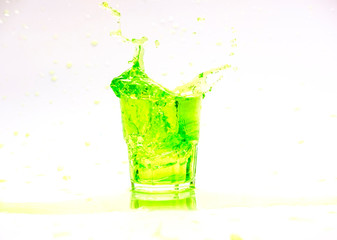green juice splash in glass isolated on white background