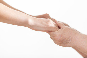 Hands of a young woman and a pensioner close up on a white background. Taking care.