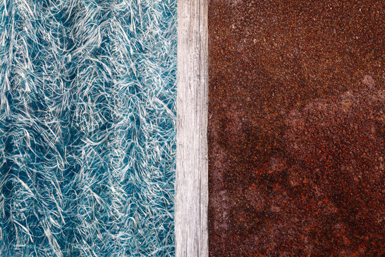 Abstraction of blue textolite slate, background in half with a rusty metal plate and a dividing strip of wood