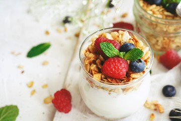 Healthy Breakfast Granola Yogurt Parfait with fresh fruits and berries, selective focus
