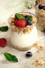Healthy Breakfast Granola Yogurt Parfait with fresh fruits and berries, selective focus