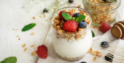 Healthy Breakfast Granola Yogurt Parfait with fresh fruits and berries, selective focus
