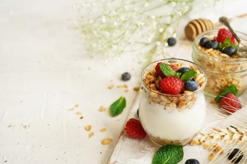 Healthy Breakfast Granola Yogurt Parfait with fresh fruits and berries, selective focus