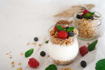 Healthy Breakfast Granola Yogurt Parfait with fresh fruits and berries, selective focus
