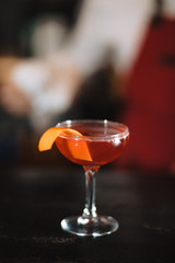 Refreshing ruby red coctail with grape fruit juice isolated on blurred bar background