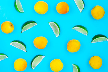 Fresh apricots and lime slices on painted wooden background