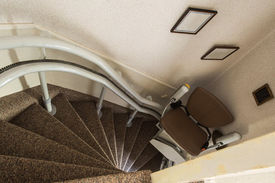 Mechanical chair lift taking disabled or aged people up and down stairs Senior, Stairlift for disabled