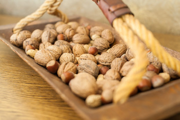 Walnuts and peanuts in wooden bowl with handle