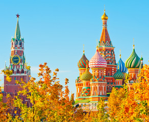 Spasskaya Tower and Cathedral of Vasily the Blessed (Saint Basil's Cathedral). Red Square. Golden foliage of trees. Sunny autumn day, blue sky. Moscow. Russia