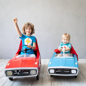 Children superheroes playing at home