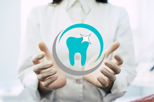 Close up photo of the Dentist hands on work place background, medical professional handed holding virtual dental object or item product. Healthcare and advertisement concept, copy space.