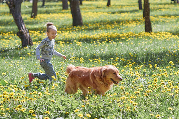 girl playing with her dog in the spring Sunny Park.