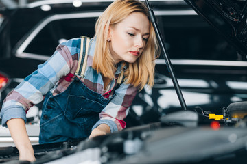 fair-haired girl looking at the wire in the hood. close up photo. copy space