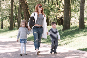 mom with two kids walking in the city Park