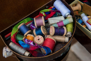 Spools of threads of different colors are in the box