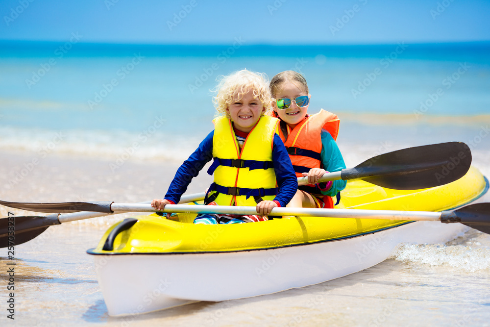 Wall mural Kids kayaking in ocean. Children in kayak in tropical sea