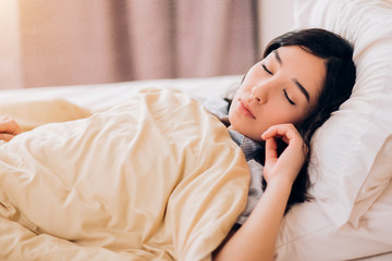 Young beautiful woman sleeping in bed, relaxing in the morning