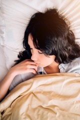 Young beautiful woman sleeping in bed, relaxing in the morning