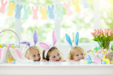 Kids on Easter egg hunt. Children dye eggs.