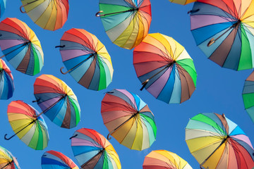 Fototapeta na wymiar Colorful umbrellas background. Colorful umbrellas in the sky. Street decoration