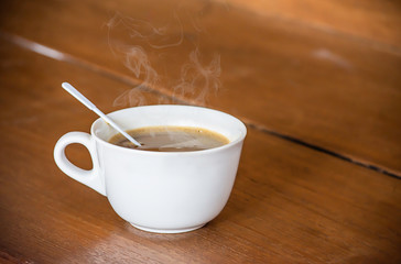 Hot coffee in white glass on wooden table