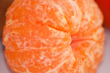 Delicious juicy peeled mandarin close-up macro