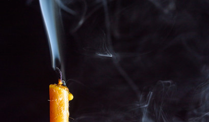 The smoke from an extinguished candle on a black background.