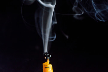 The smoke from an extinguished candle on a black background.