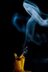The smoke from an extinguished candle on a black background.