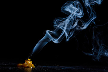 The smoke from an extinguished candle on a black background.