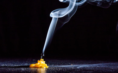 The smoke from an extinguished candle on a black background.